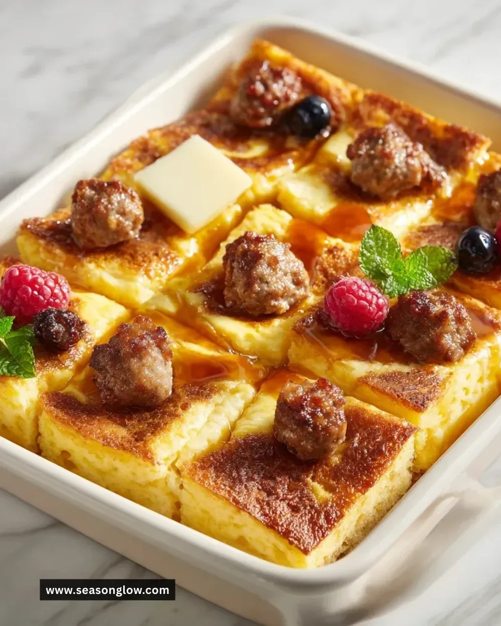 Delicious pancake sausage casserole served on a plate with syrup and berries