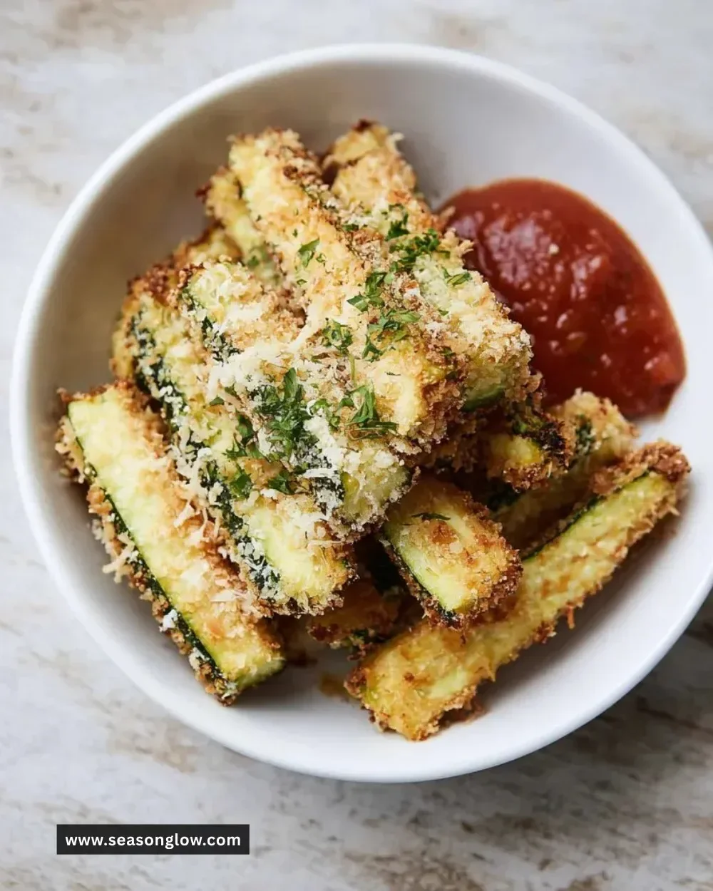 Baked Parmesan Zucchini Fries served on a plate, garnished with herbs.