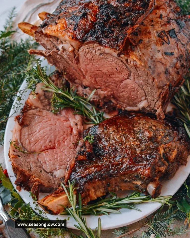 Juicy and perfectly cooked prime rib roast served with herbs and sides.