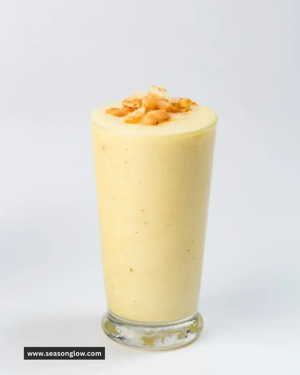 Pineapple Coconut Smoothie in a glass with tropical fruits