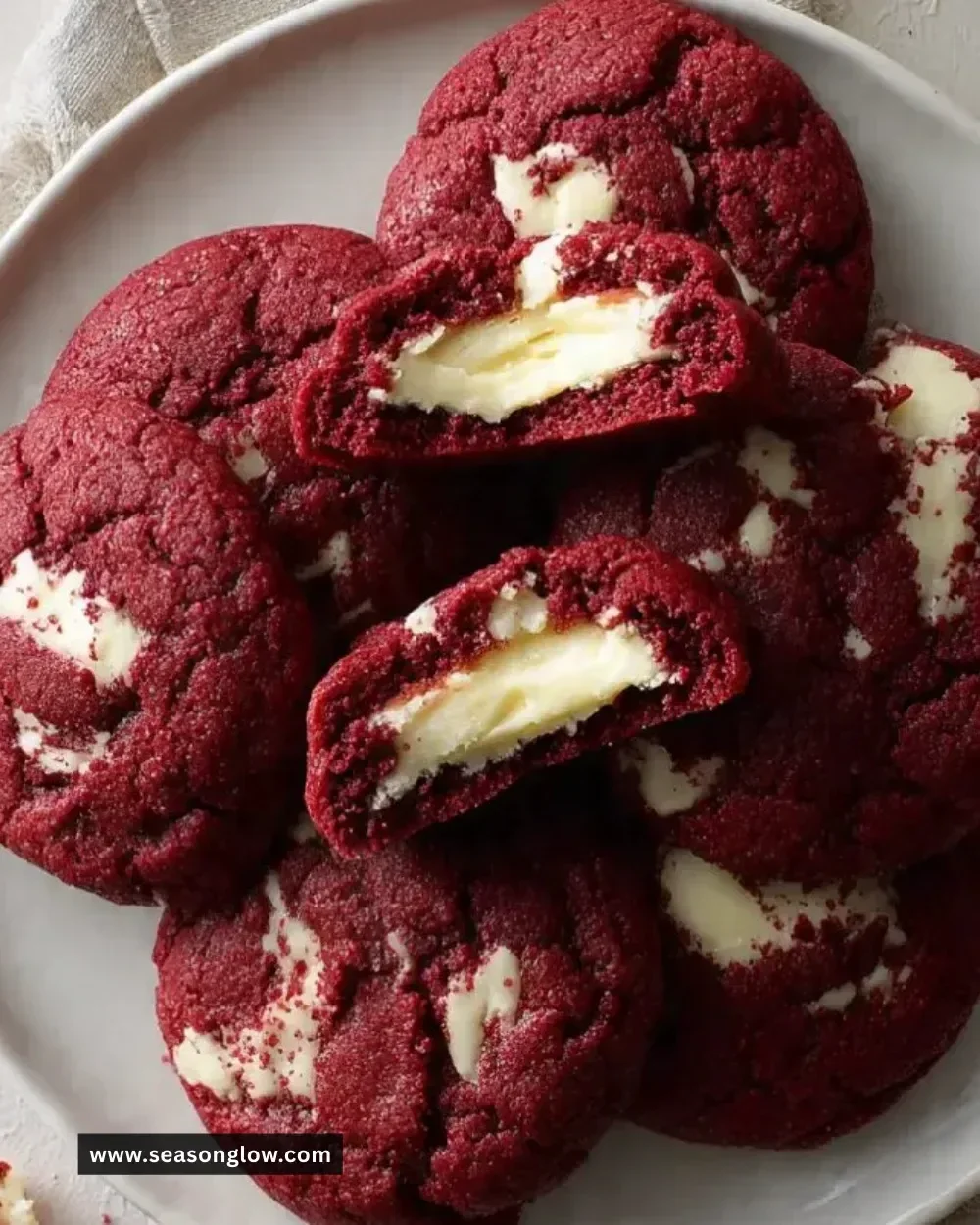 Freshly baked red velvet cookies with cream cheese filling on a cooling rack
