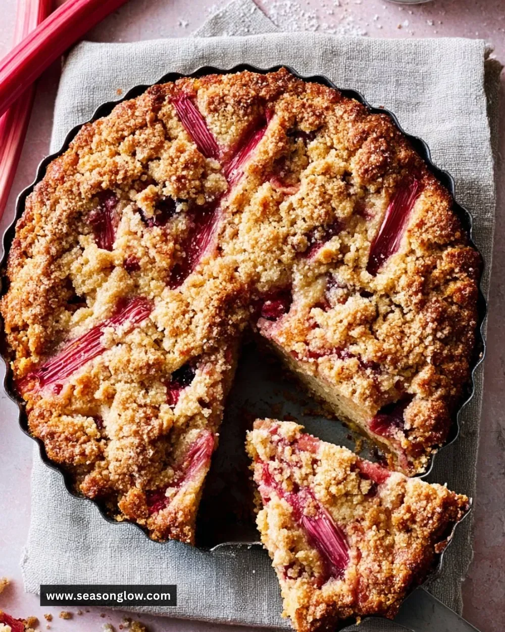 Delicious Rhubarb Buckle dessert with crumbled topping and fresh rhubarb.