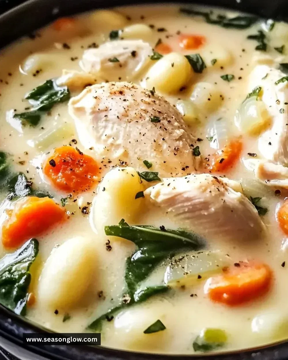 Bowl of Slow Cooker Chicken Gnocchi Soup garnished with herbs