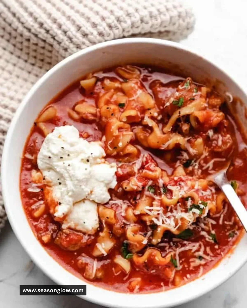 Bowl of Slow Cooker Lasagna Soup topped with cheese and herbs