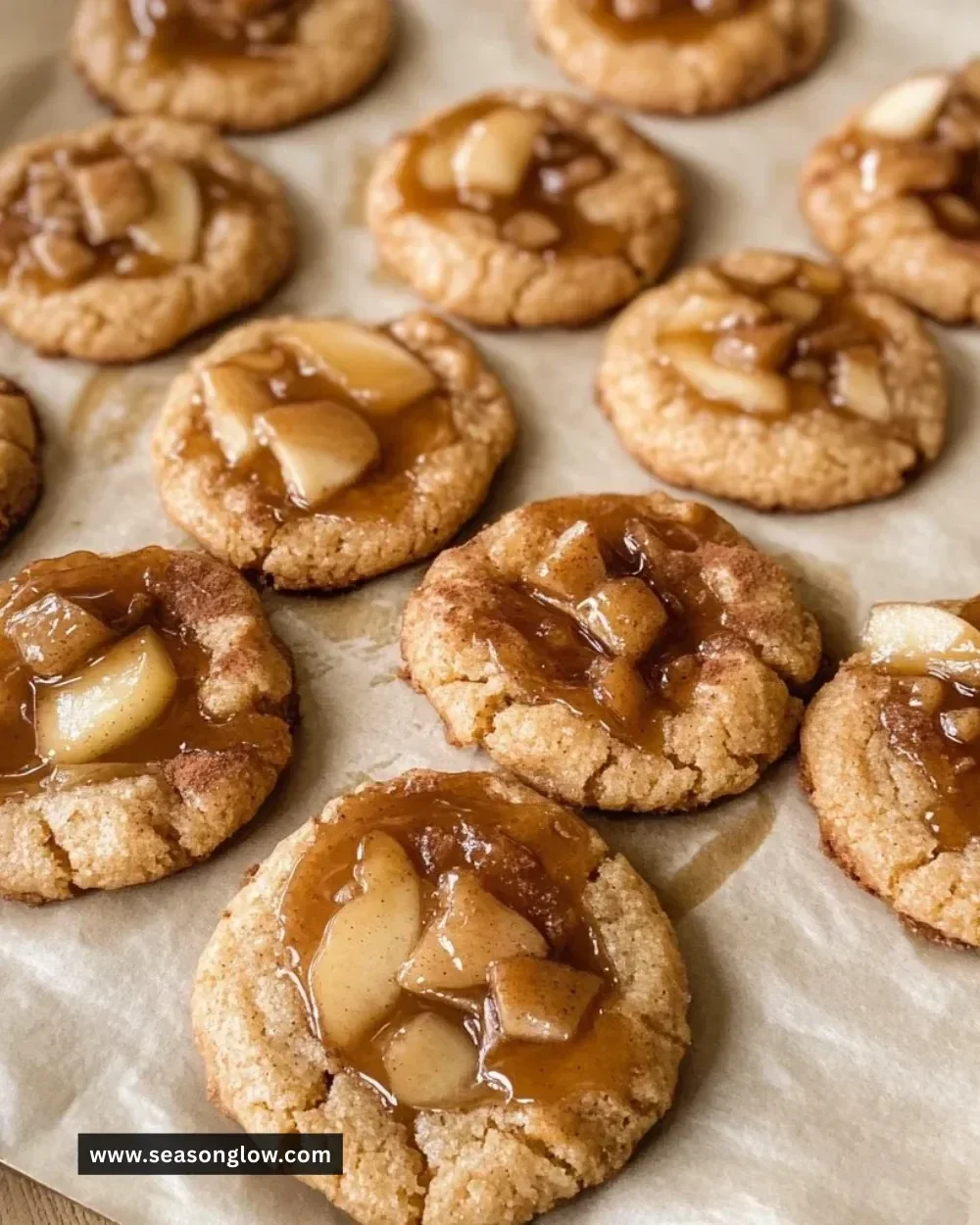 Soft and chewy apple pie cookies on a wooden table with a slice of apple