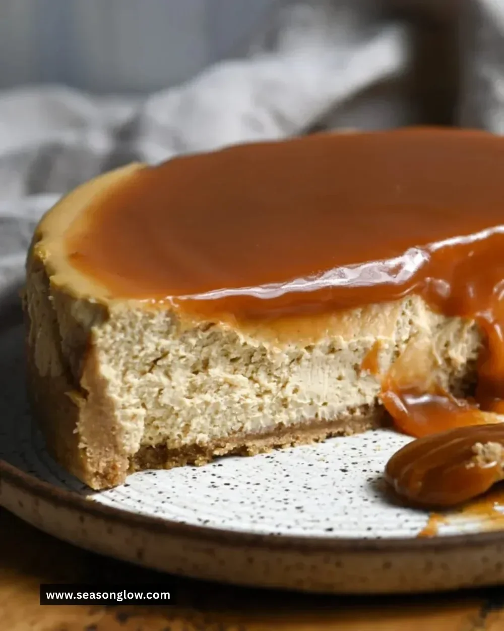 Slice of spiced apple cider cheesecake topped with cinnamon and apple slices.