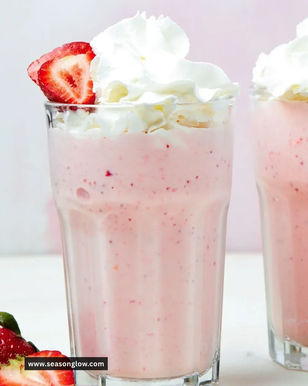 Delicious homemade strawberry milkshake topped with whipped cream and fresh strawberries