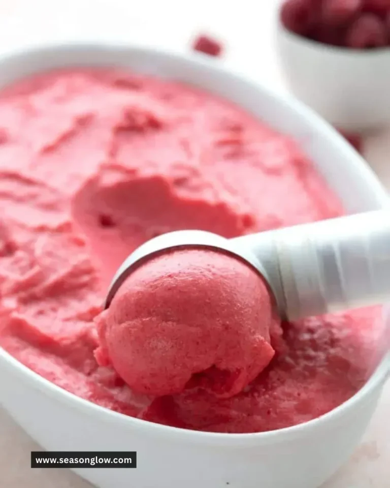 Sugar free keto raspberry sorbet in a bowl with fresh raspberries.