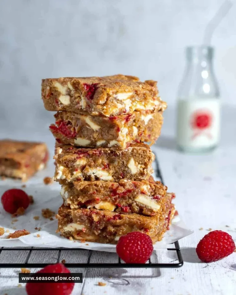 Delicious chocolate raspberry blondies topped with white chocolate and raspberries.