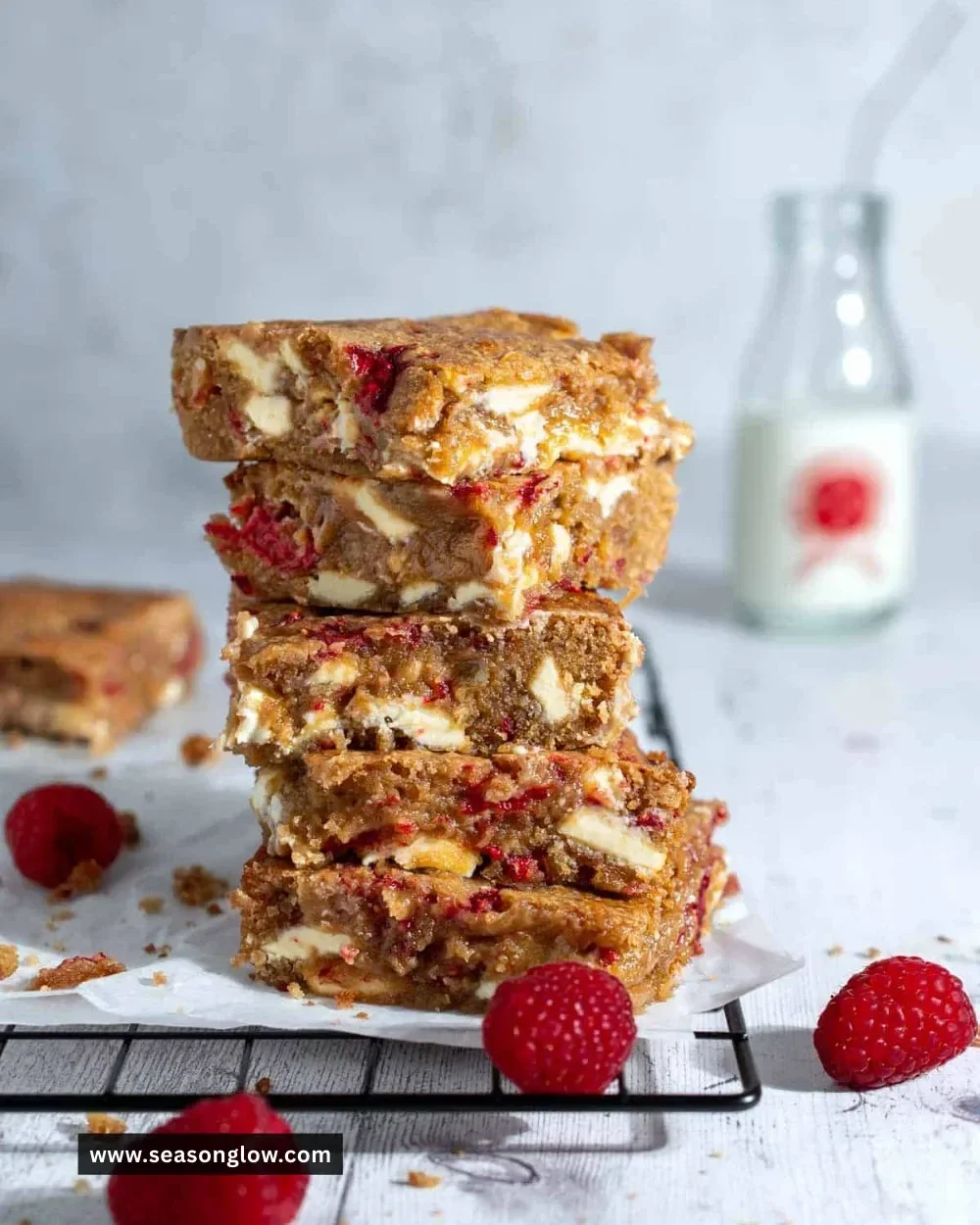Delicious chocolate raspberry blondies topped with white chocolate and raspberries.