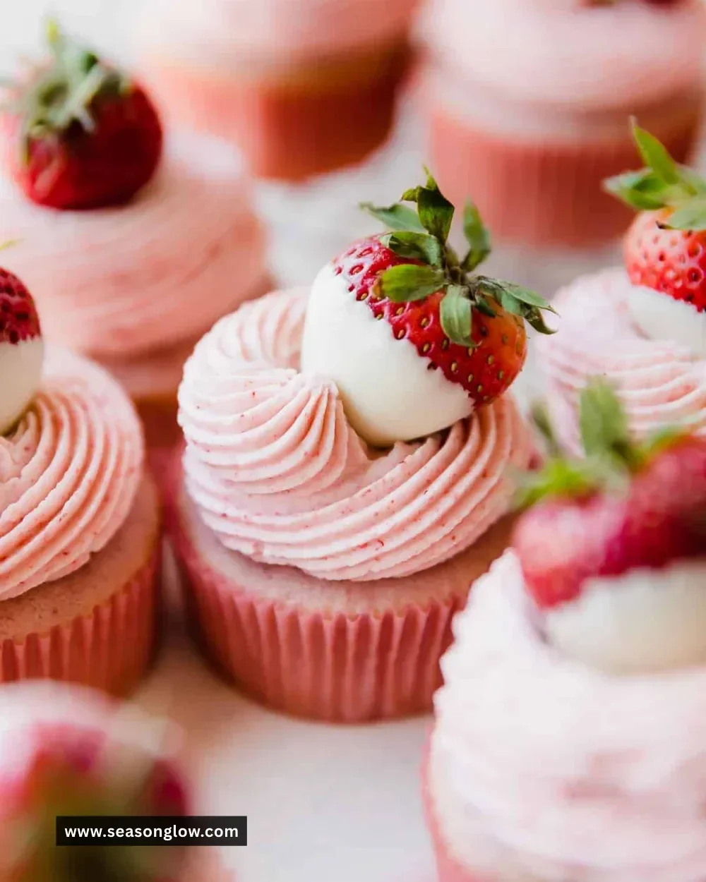 Delicious white chocolate strawberry cupcakes on a decorative plate