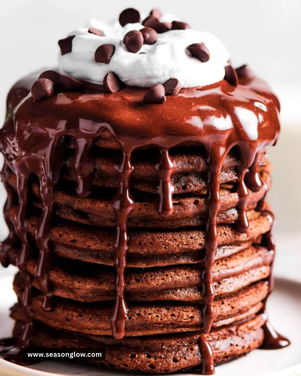 Delicious homemade chocolate pancakes served with syrup and berries