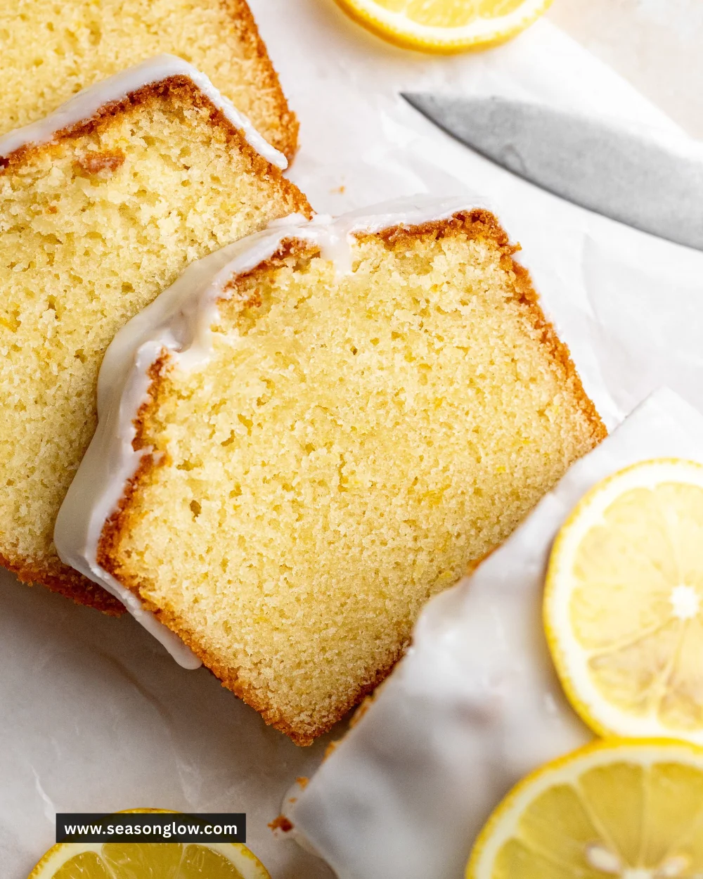 Sliced lemon loaf with a glazed topping, showcasing a moist texture and citrus flavor.