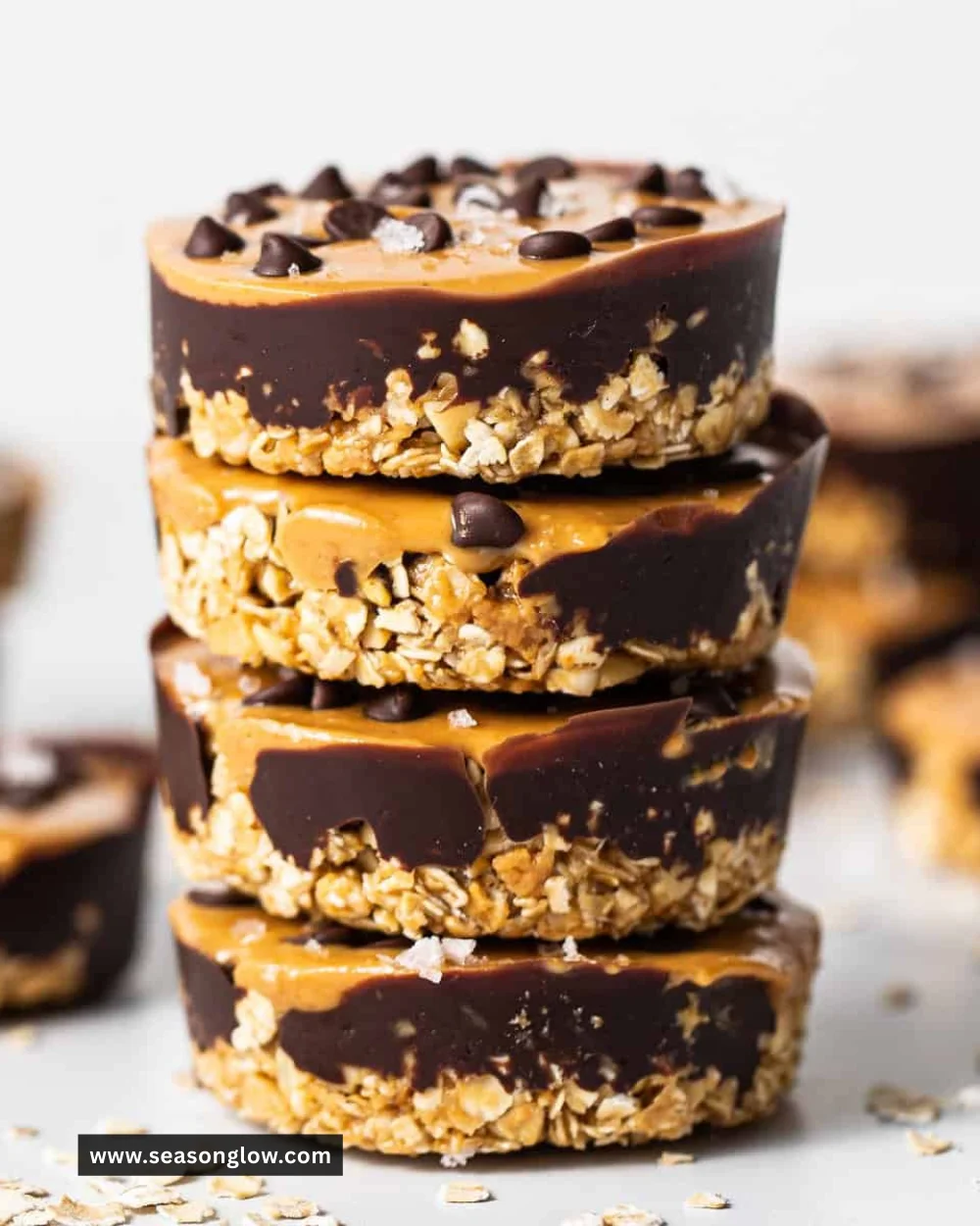 No bake peanut butter oat cups with chocolate topping on a white plate.