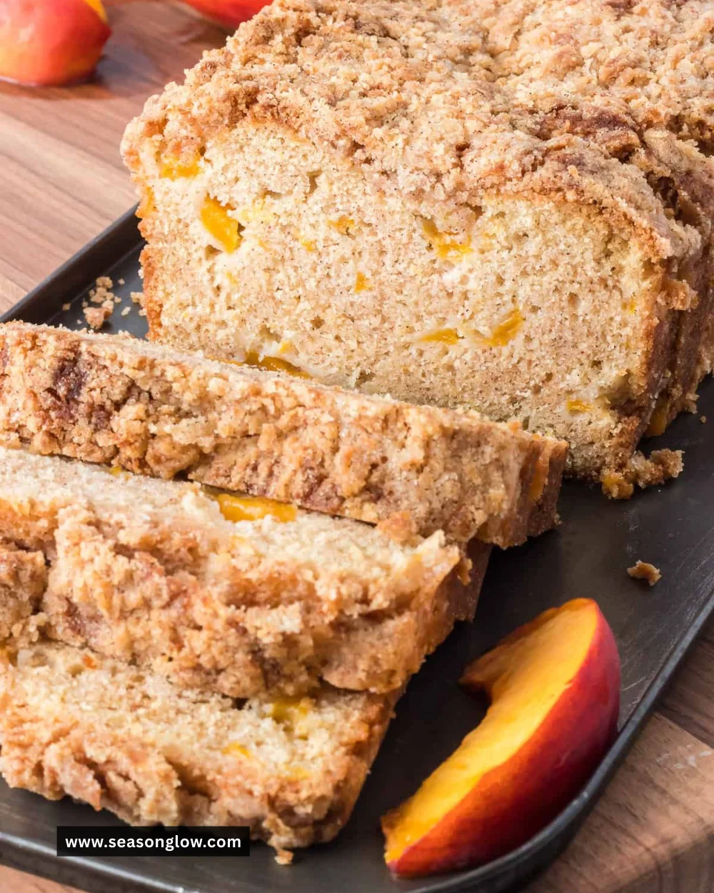 Loaf of freshly baked peach bread garnished with slices of peach