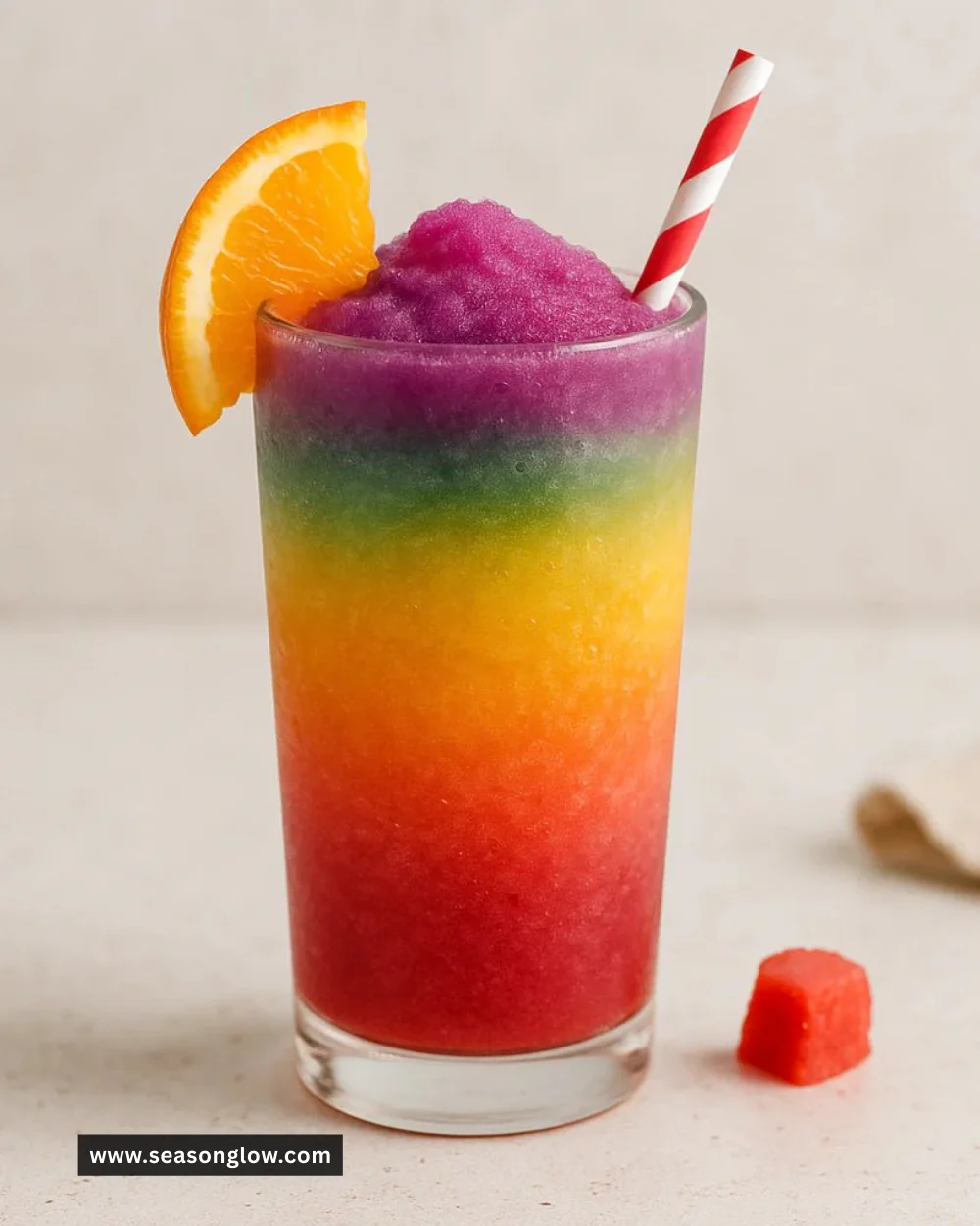 Colorful Rainbow Slushie in a clear cup with a colorful straw