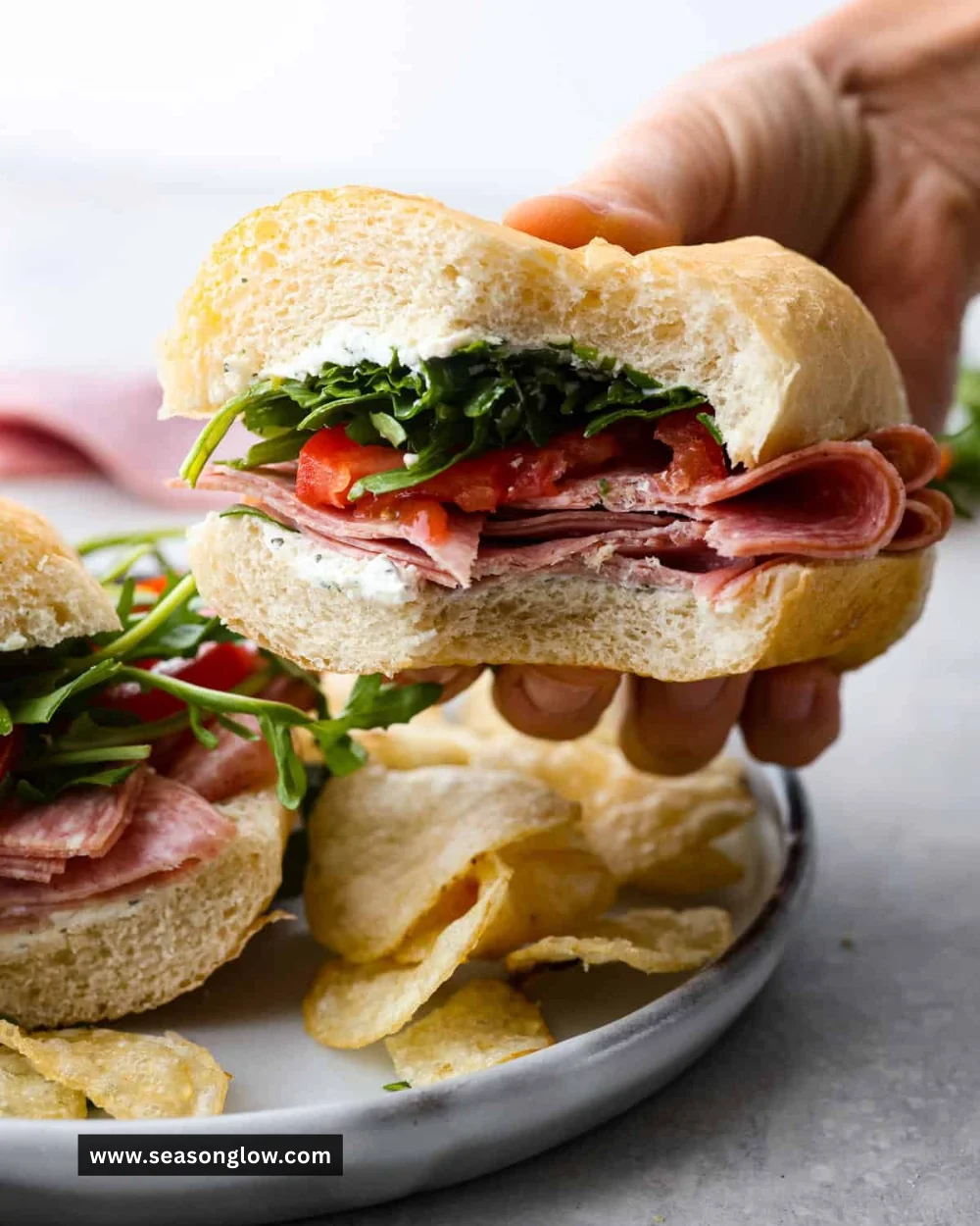 Delicious salami sandwich with fresh ingredients on a wooden board.