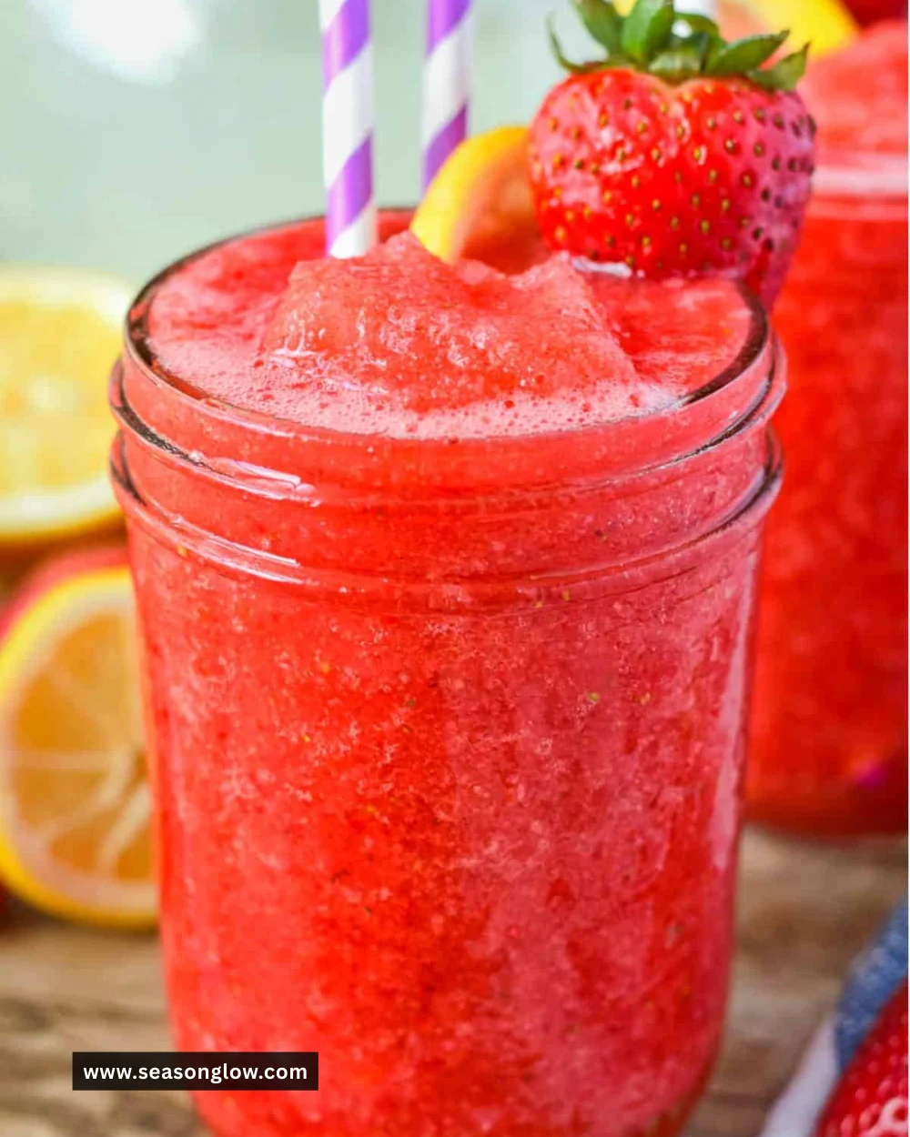 Refreshing strawberry lemonade slushie in a glass with ice and fresh strawberries