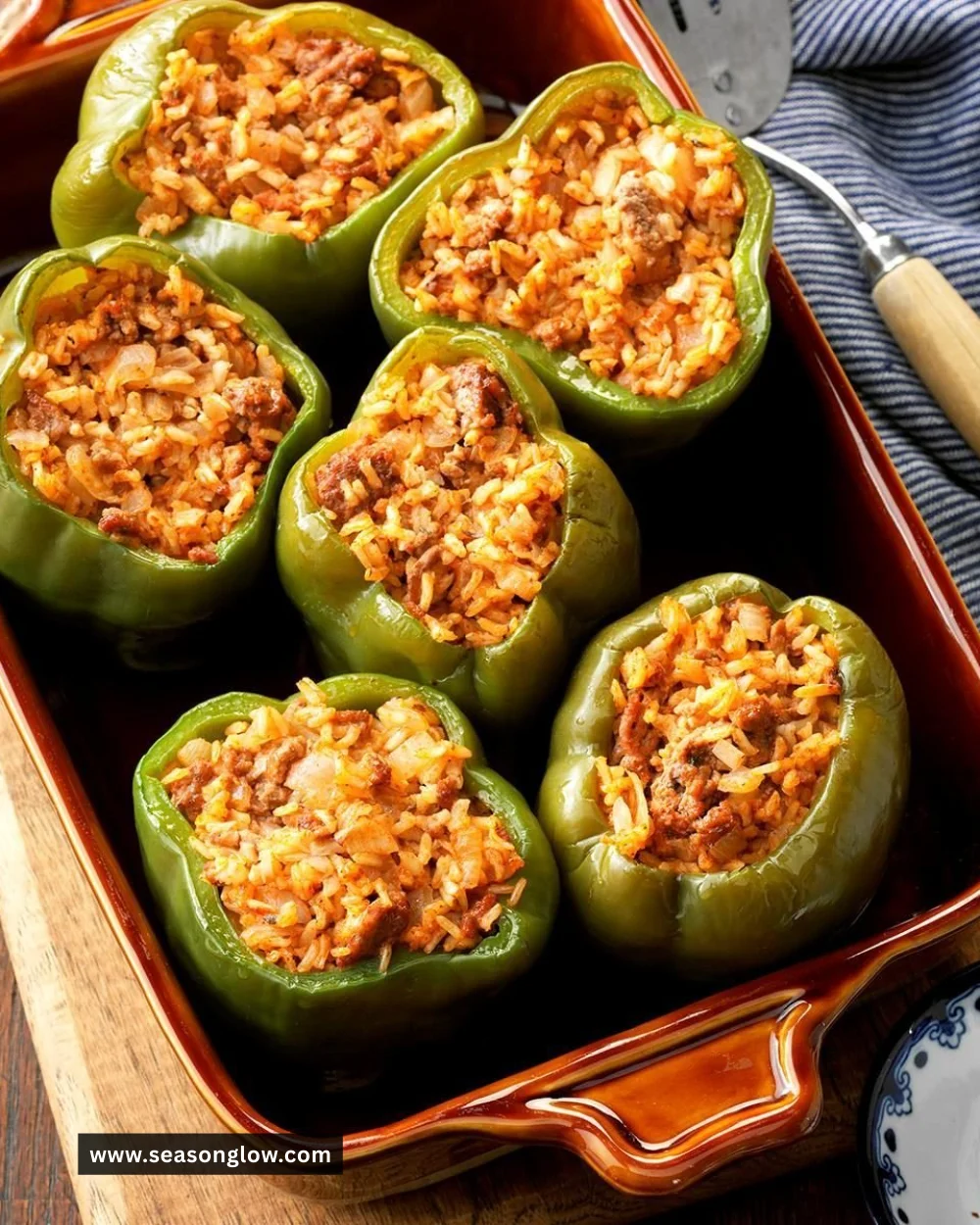 Stuffed peppers filled with rice, served on a plate, showcasing a colorful meal.