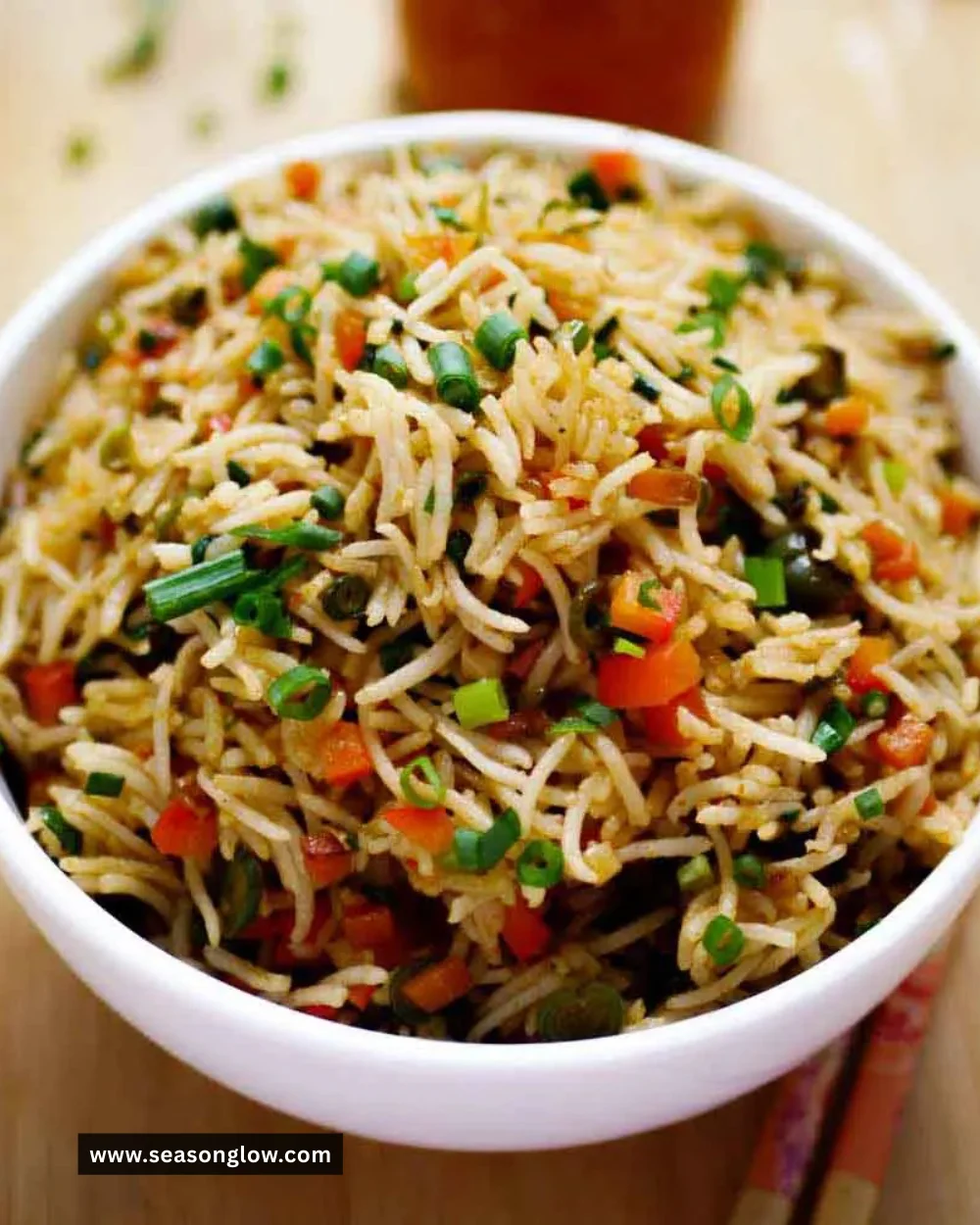 Plate of colorful vegetable fried rice with fresh vegetables and herbs.