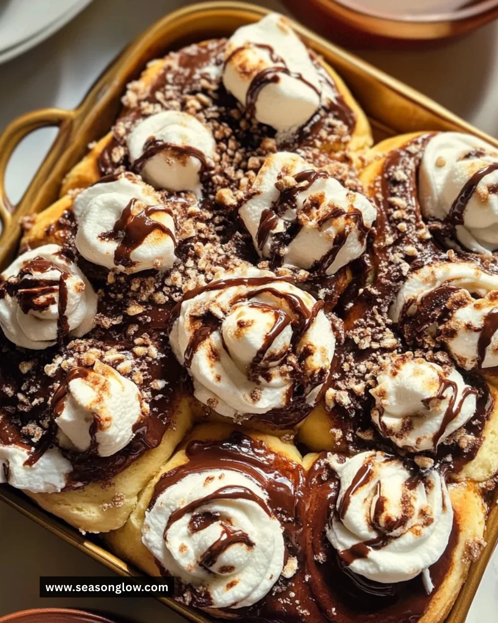 Delicious hot cocoa cinnamon rolls topped with vegan marshmallows frosting.
