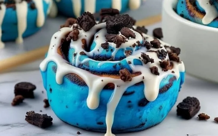 Delicious Cookie Monster Cinnamon Rolls topped with blue icing and sprinkles