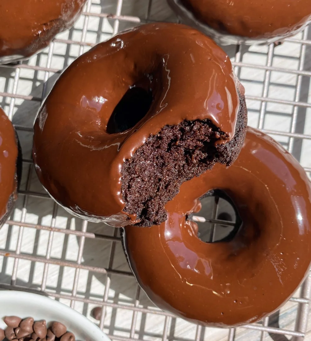 Healthy chocolate protein donuts topped with chocolate icing and nuts