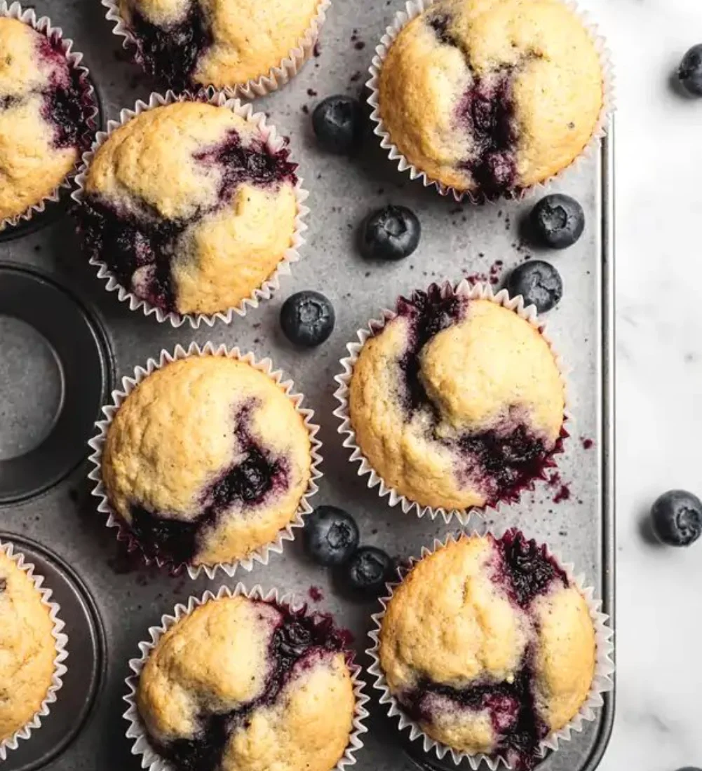 Homemade blueberry protein muffins fresh out of the oven with blueberries