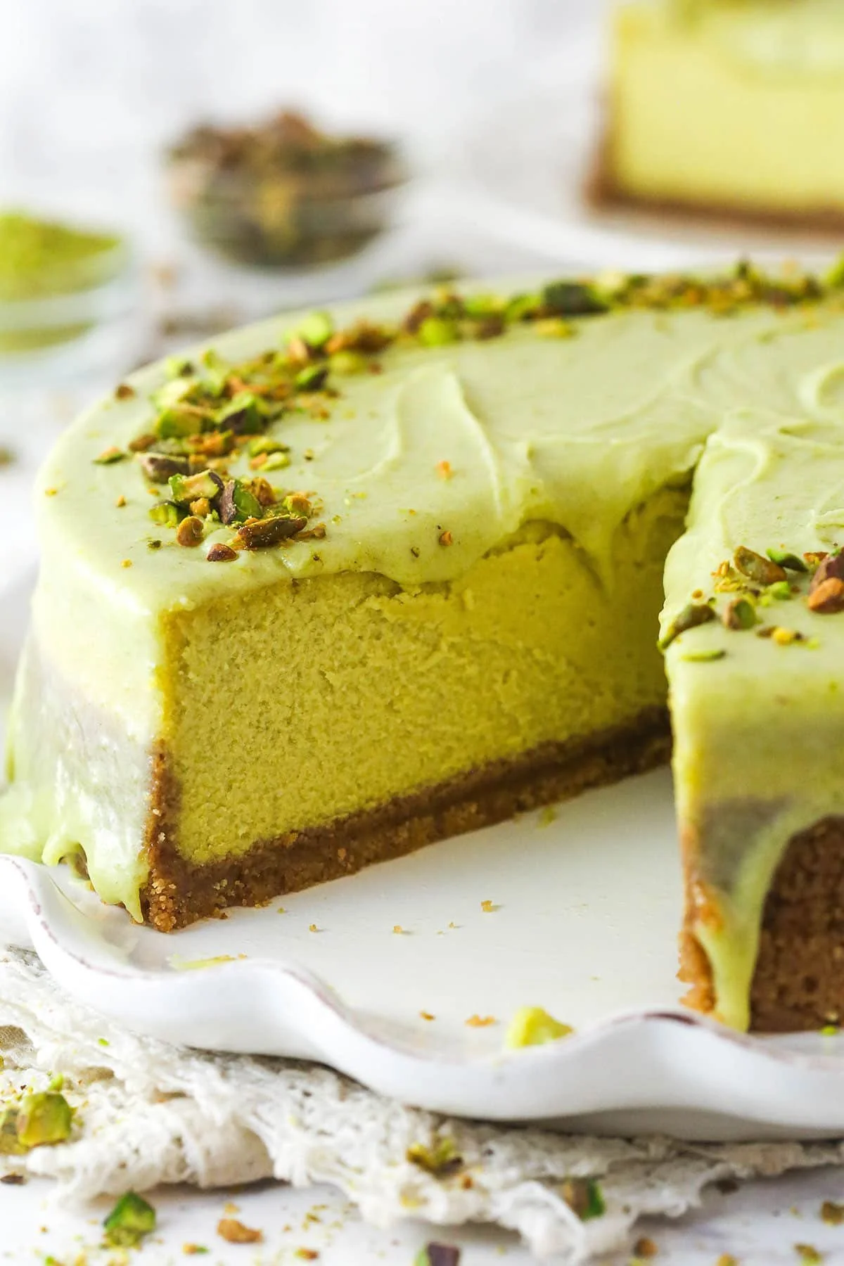 Delicious slice of pistachio cheesecake garnished with pistachios and whipped cream