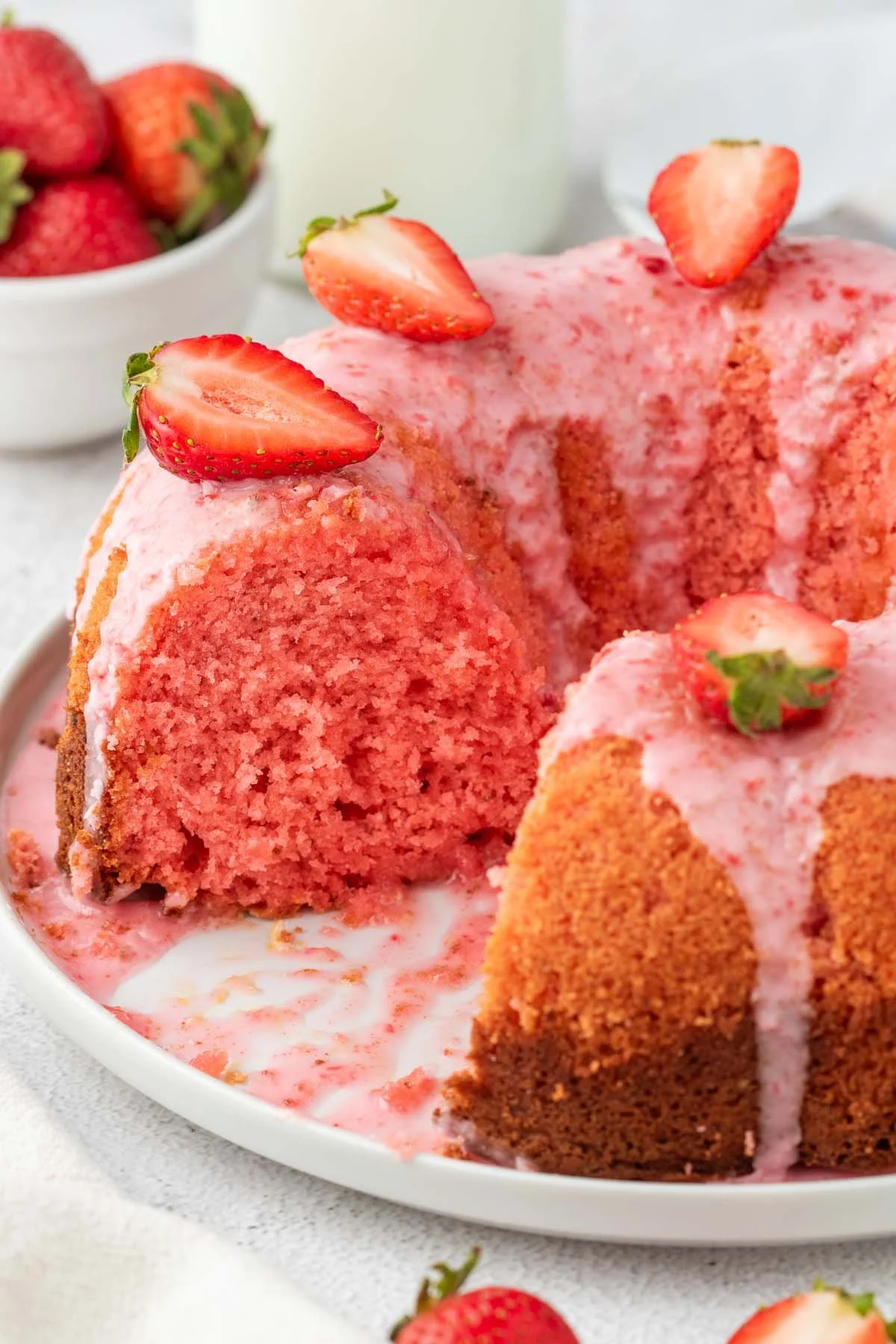 Delicious homemade Strawberry Bundt Cake topped with fresh strawberries and cream.