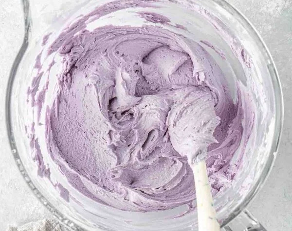 Delicious vegan lavender buttercream on a cupcake, decorated with flowers.