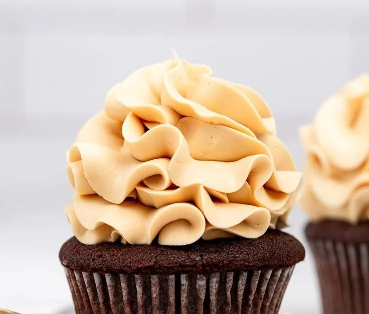 Delicious caramel buttercream frosting spread on a chocolate cupcake