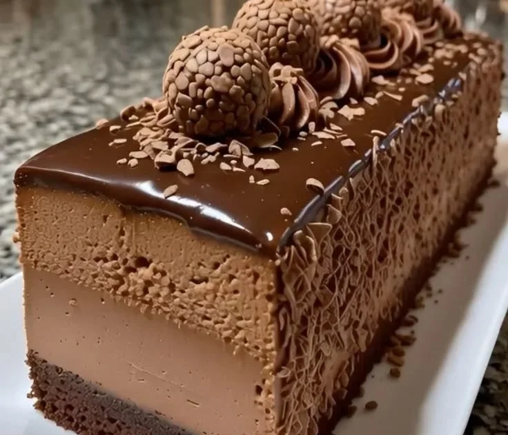 Slice of dark chocolate truffle mousse cake on a plate with chocolate shavings