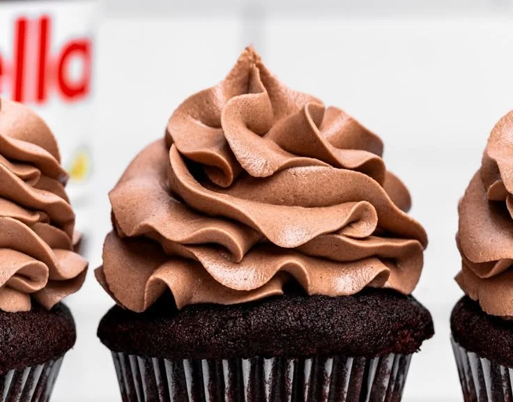 Delicious Nutella frosting spread on a chocolate cupcake with chocolate sprinkles.