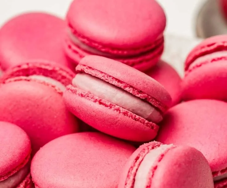 Beautifully crafted Raspberry Macarons displayed on a decorative plate.