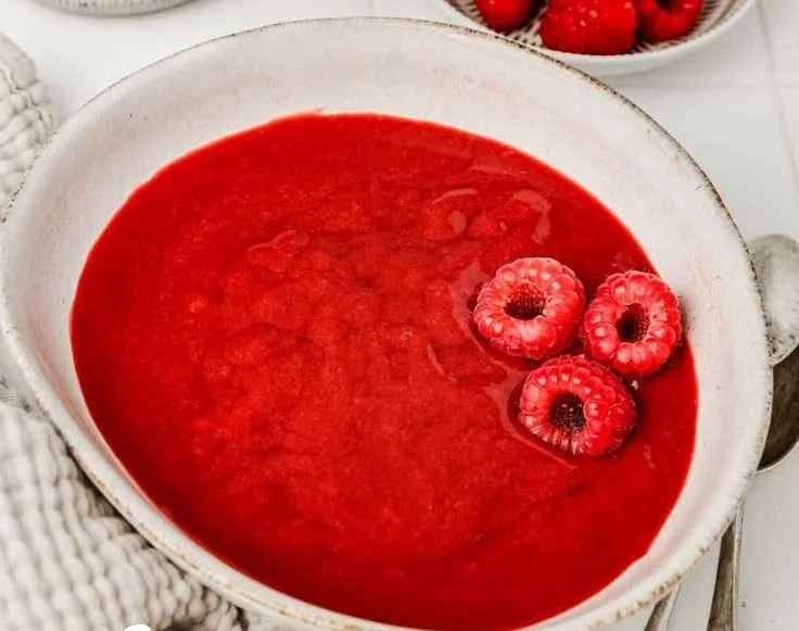 Delicious raspberry sauce drizzled over a slice of cheesecake