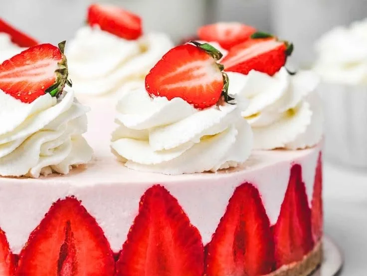 Delicious strawberry cheesecake topped with fresh strawberries and whipped cream