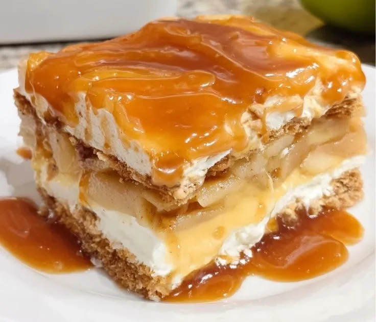 Caramel Apple Eclair Cake topped with caramel sauce and apple slices.